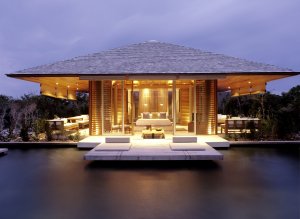 private villa mit terrasse über dem pool wasser und viel licht mit glas wänden aus viel holz im luxuriösen modernen designer hotel und resort auf den turks- und caicosinseln in der karibik 